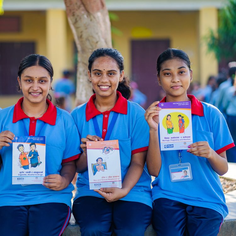 Four young girls are holding a book related to SRHR.