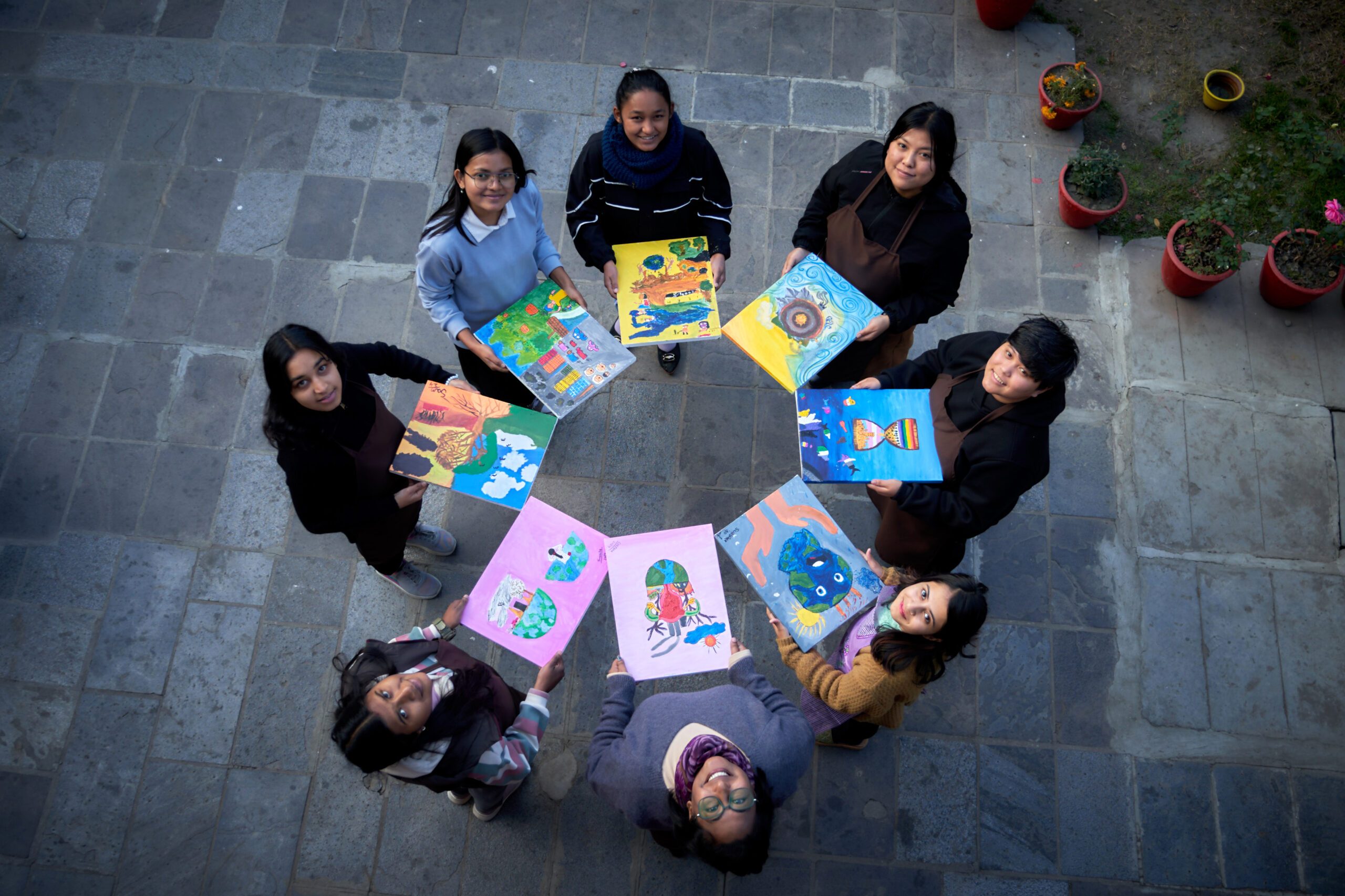 Youth activists holding their paintings on climate justice and education.