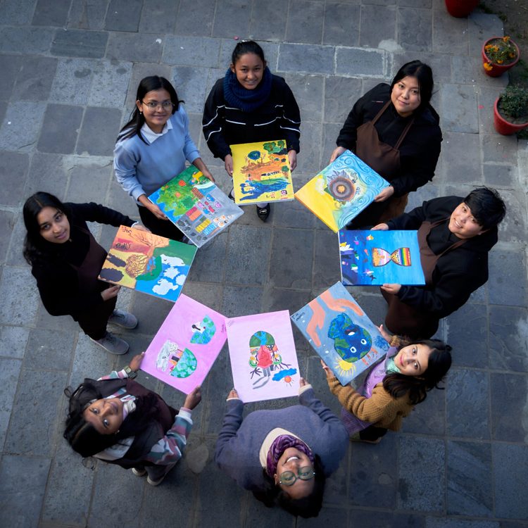Youth activists holding their paintings on climate justice and education.