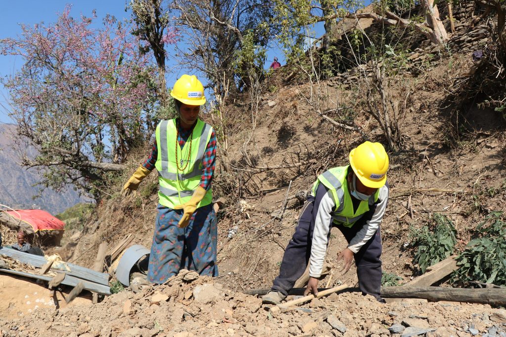 Deukali and Kaliram are clearing the debris from their roof.