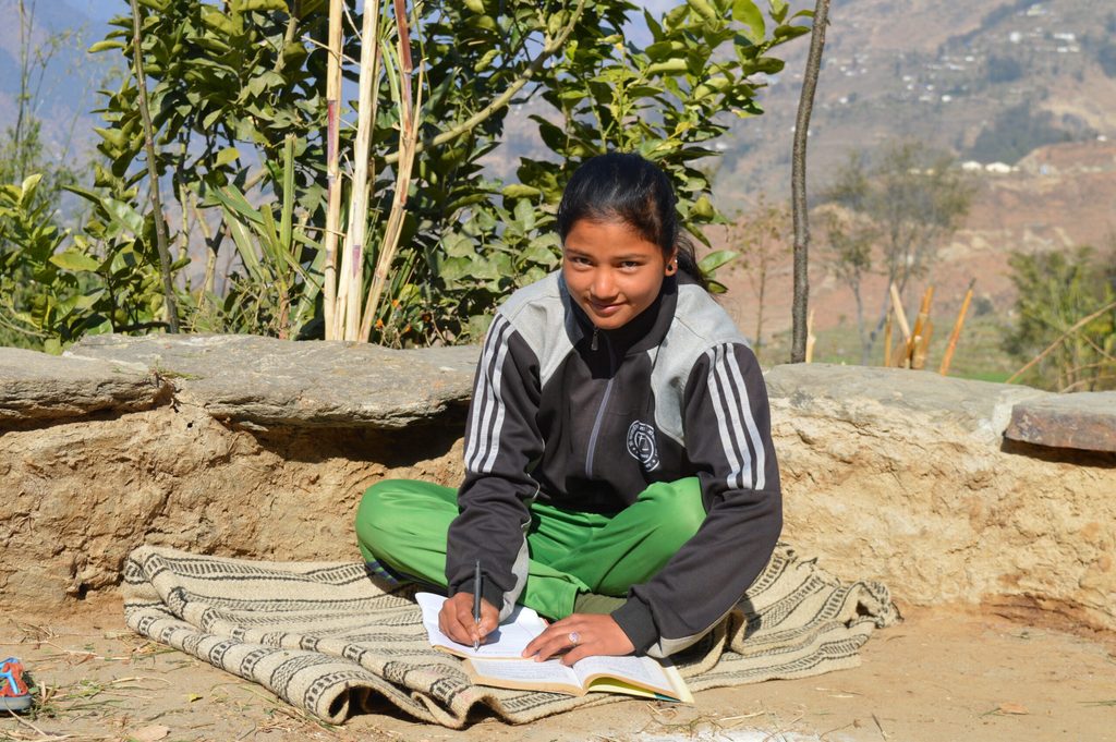 A young girl writing in her note book.