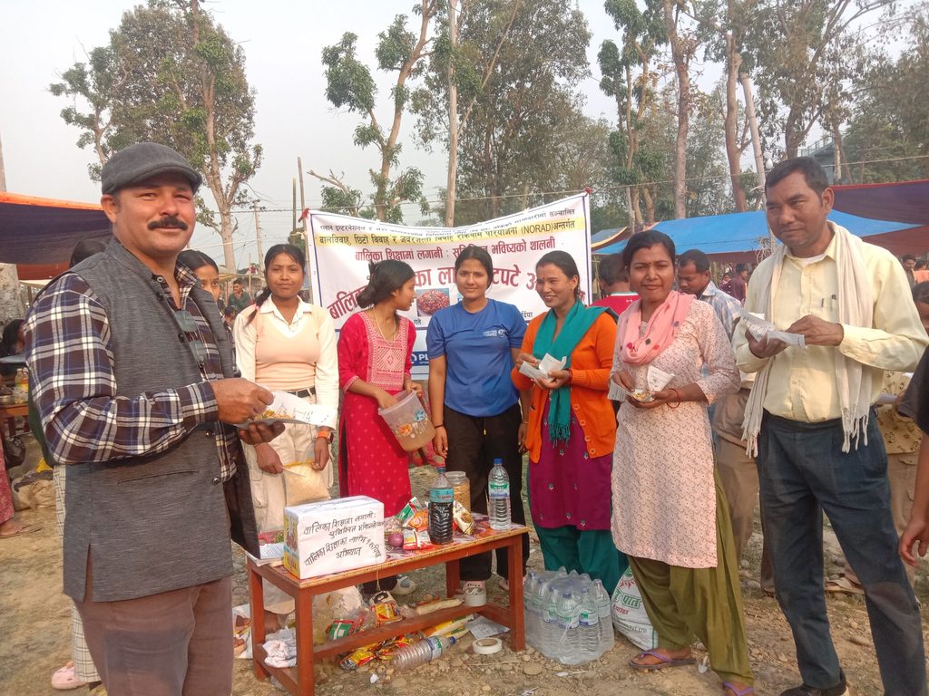 Group of people standing and enjoying snack.