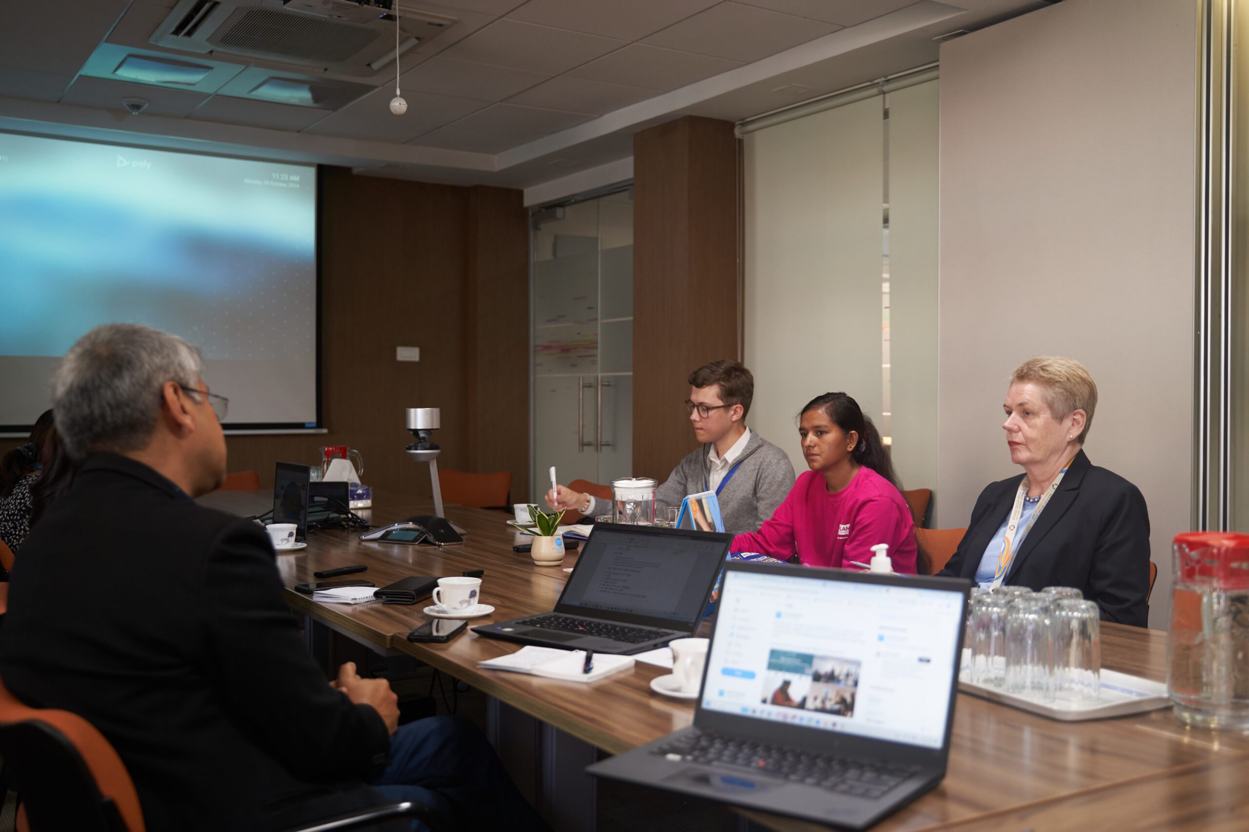 A group of people including Lalita in a meeting with UNICEF team. 