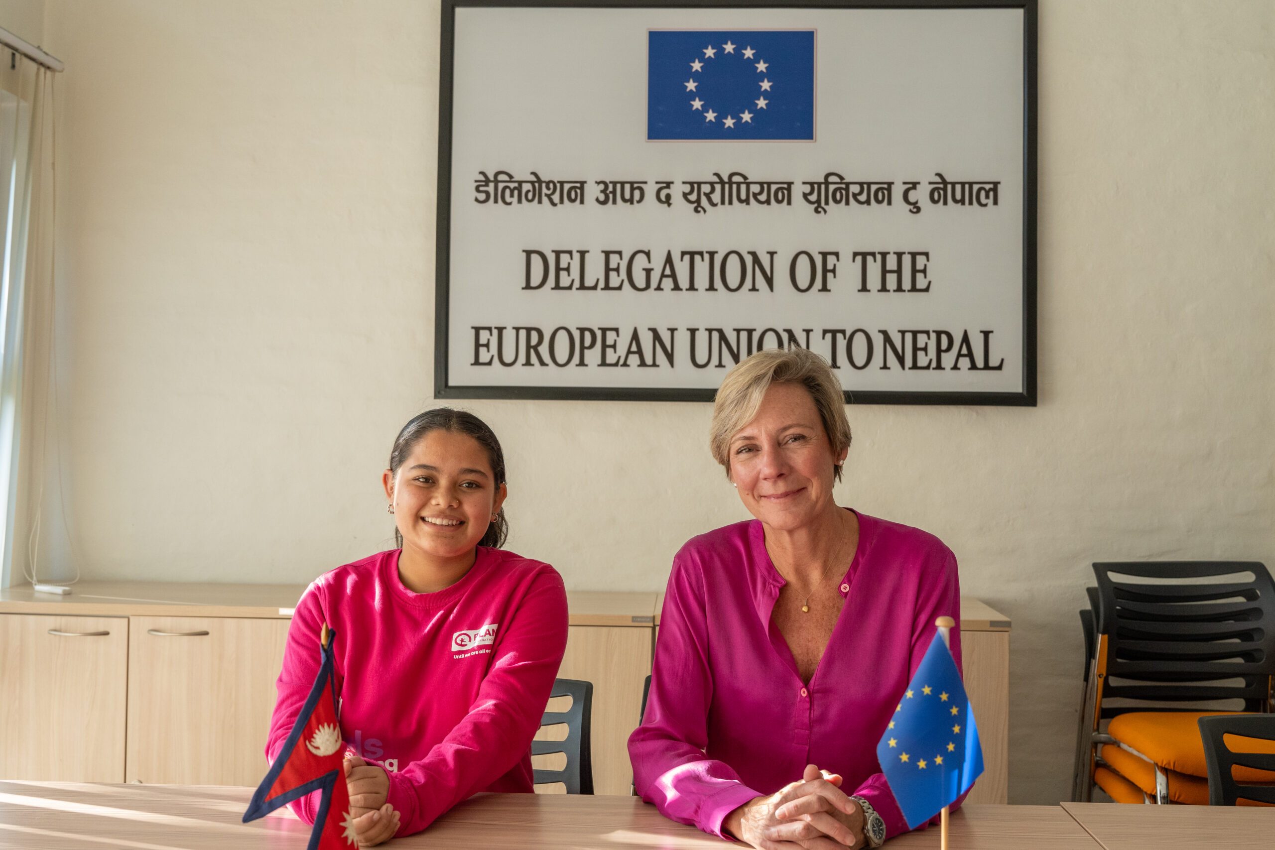 Ranjita on left and H.E. Veronique with EU and Nepal flags on the table.