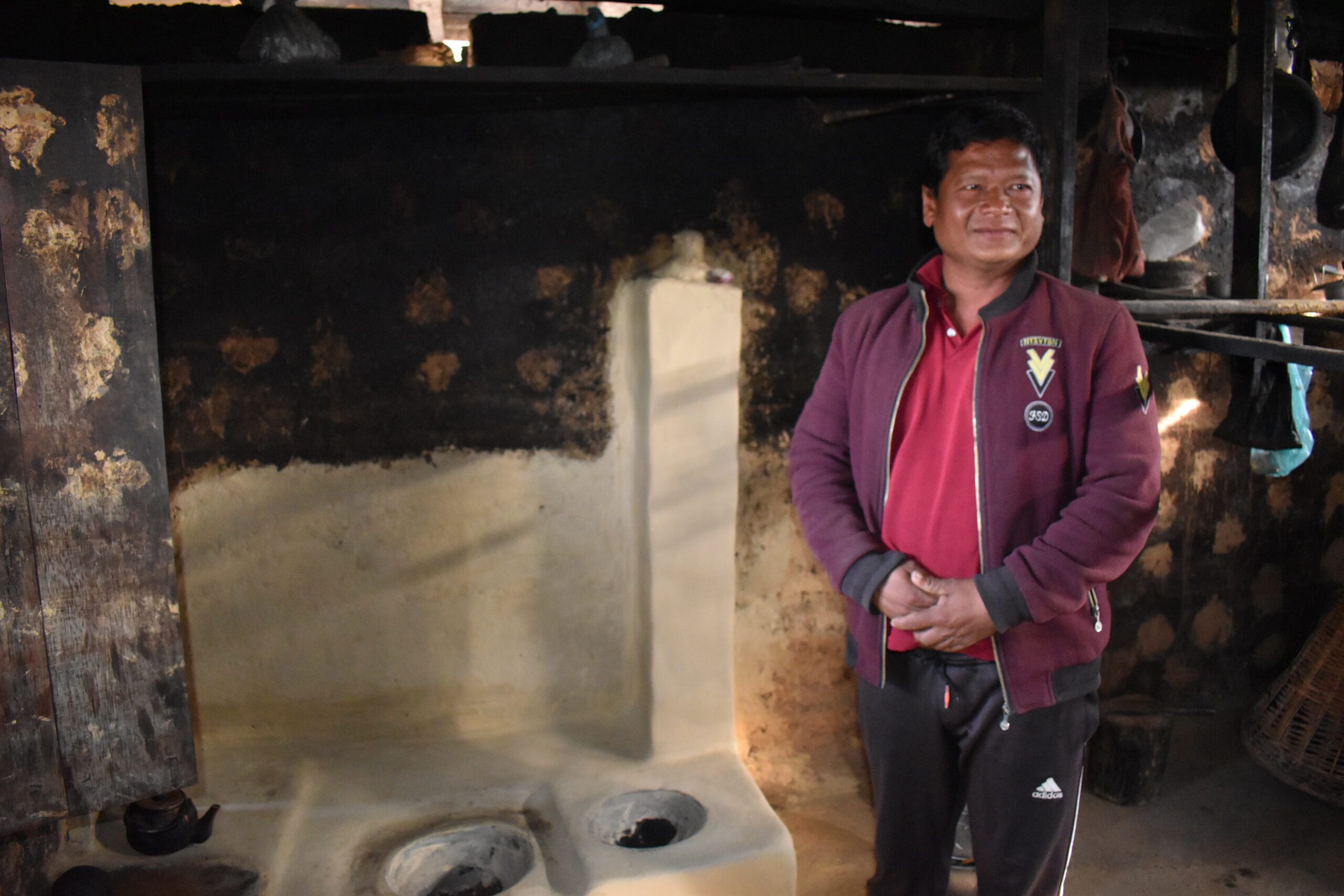 A middle aged man, Chandraman standing in front of newly built ICS in his kitchen. 