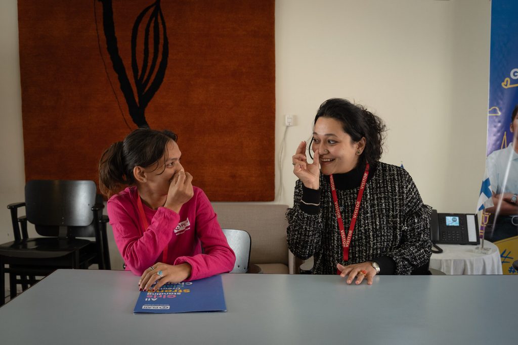 Balkumari on left using sign language with Aayushi, the CEO of Khalisis on right.