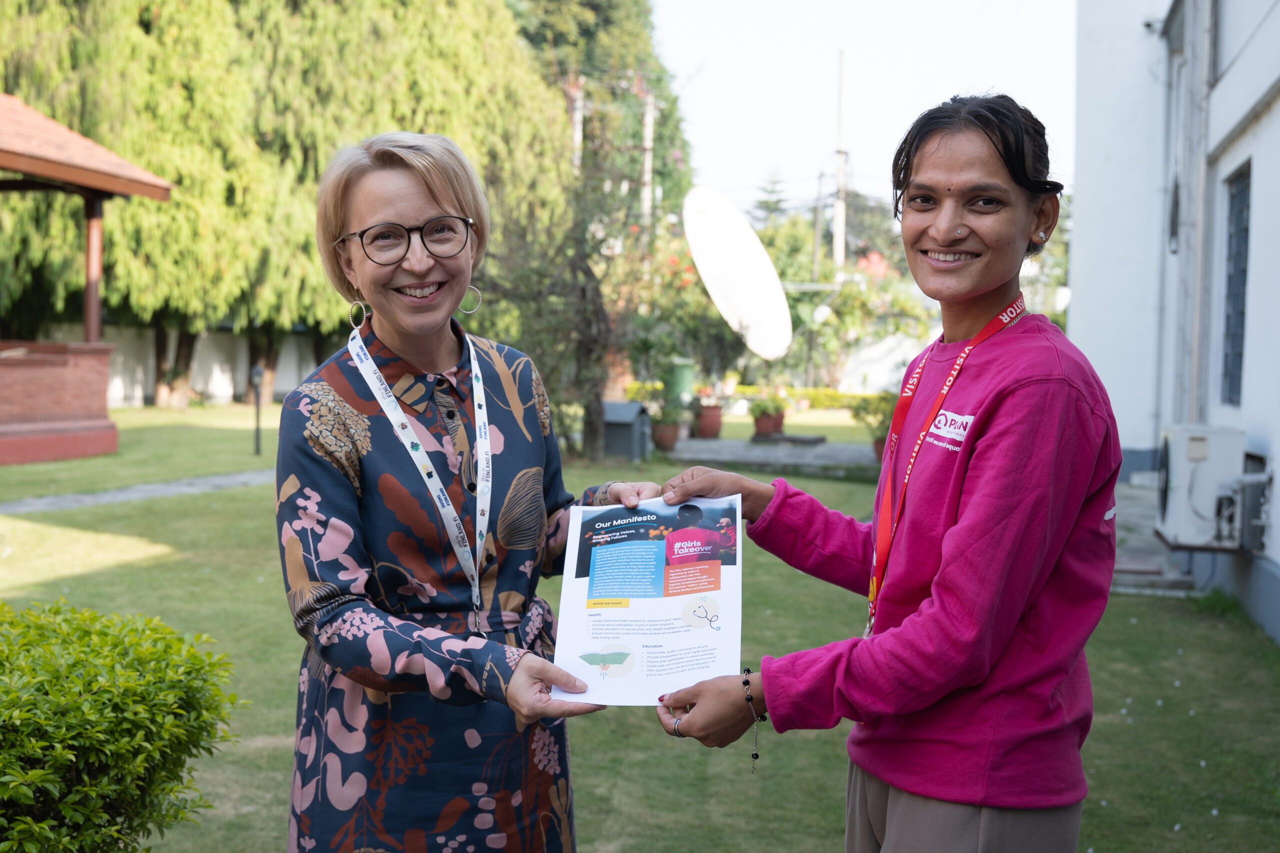 H.E. Rina Reikka Hikka on left receiving a girls manifesto from Balkumari on right.