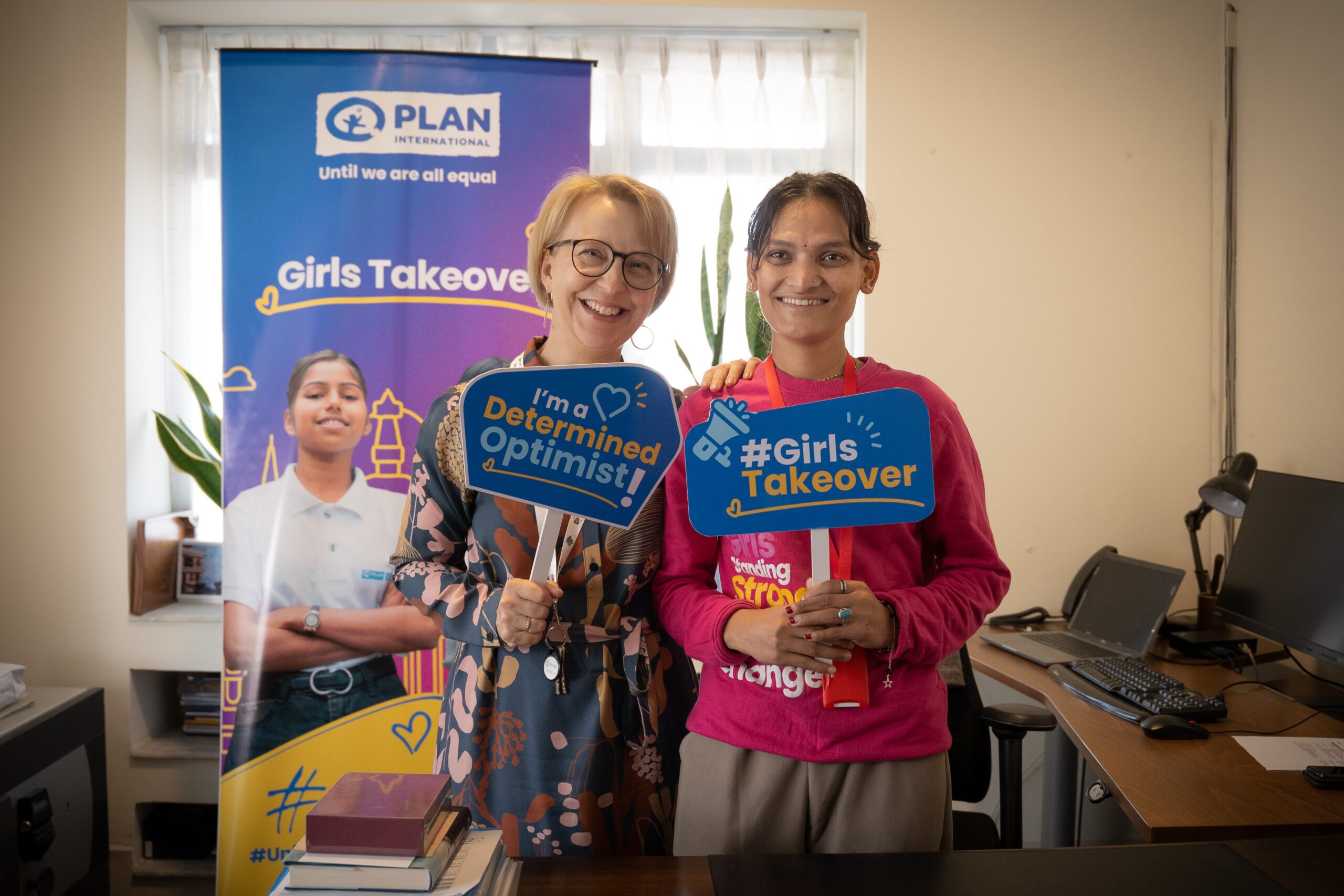 H.E. Rina Reikka Hikka, , the Finnish Ambassador to Nepal on left and Balkumari on right holding placards during Girls Takeover.