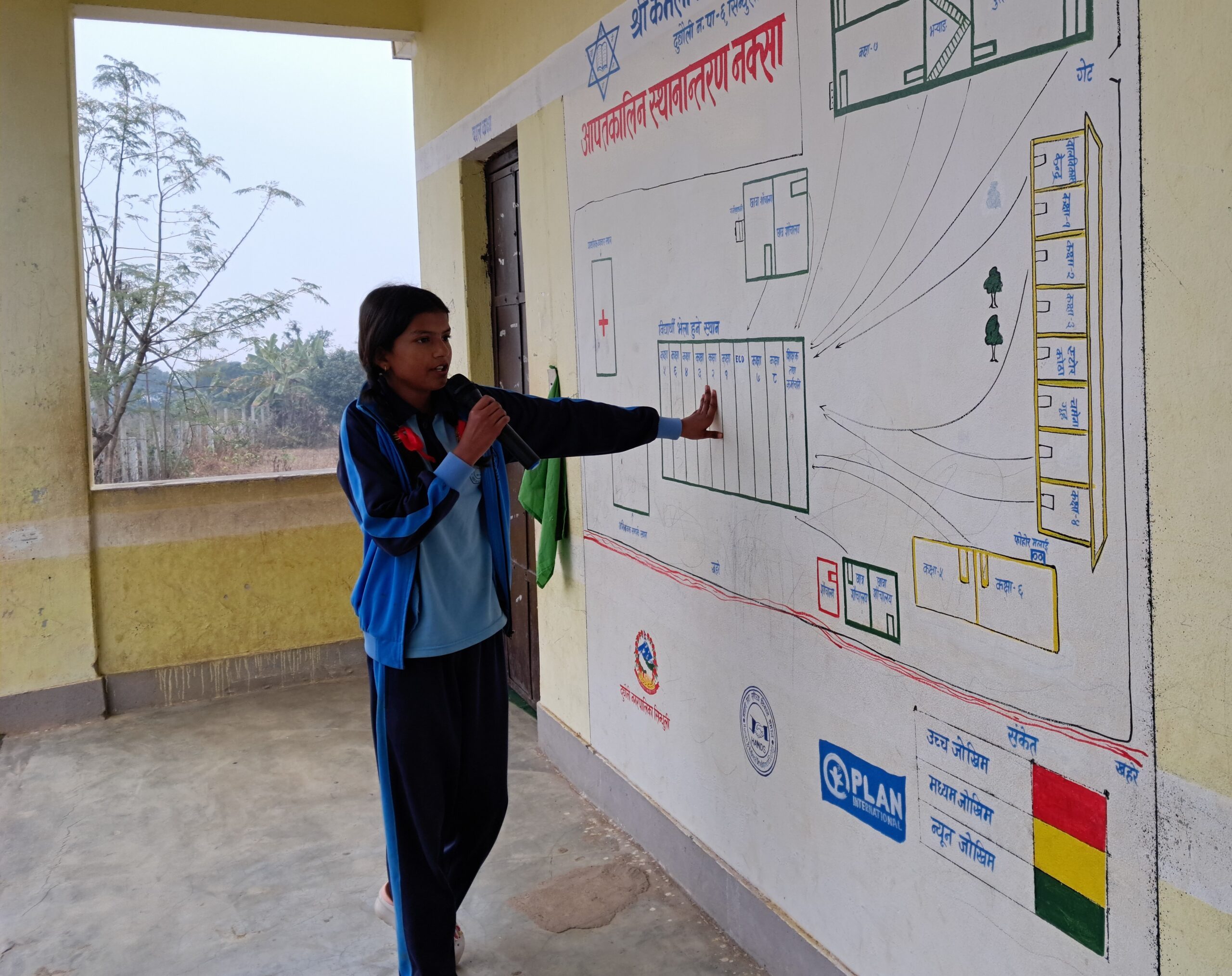 A young girl Sanju, wearing school uniform, holding mic and reading content from the wall
