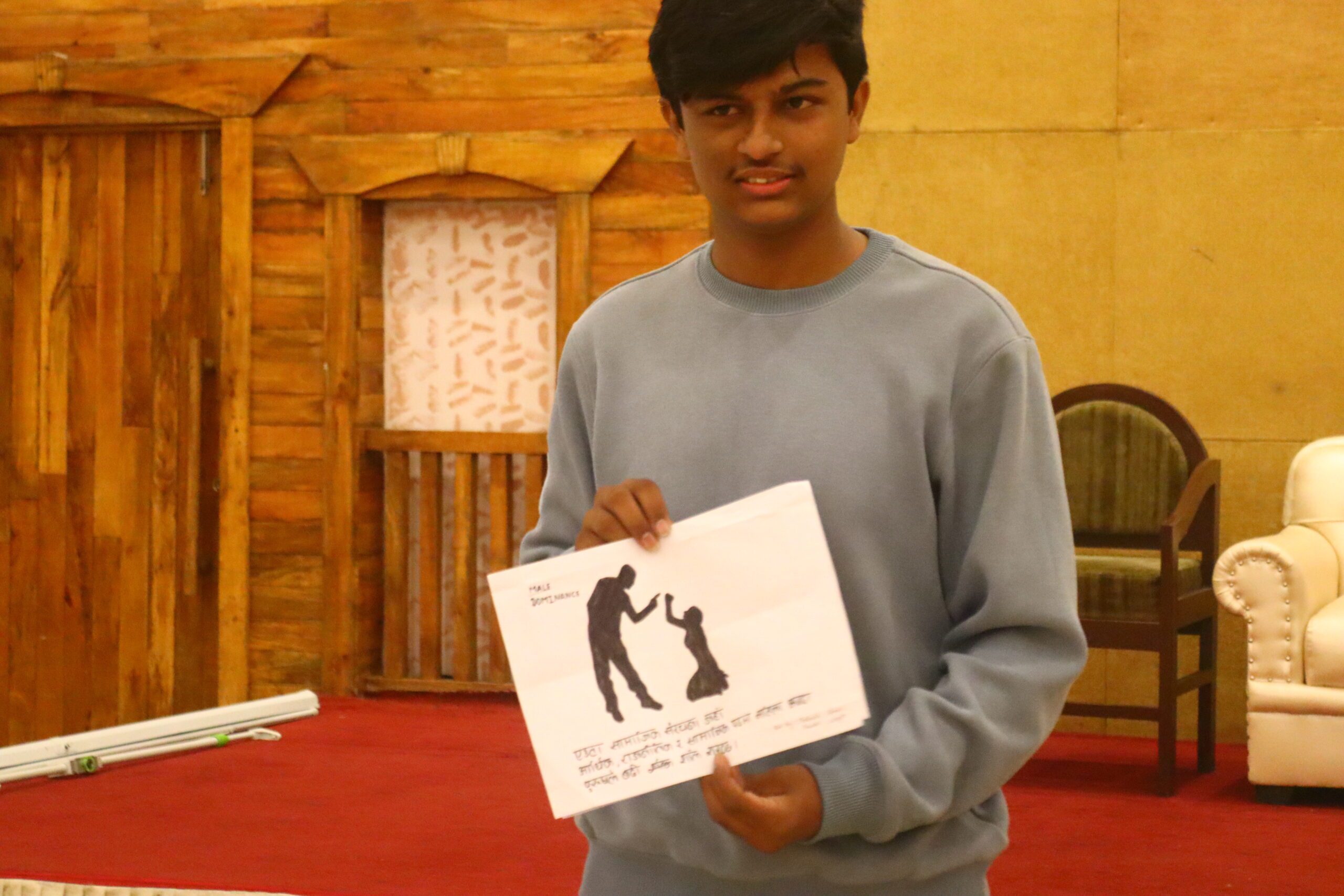 A young man holding a art on gender based violence.