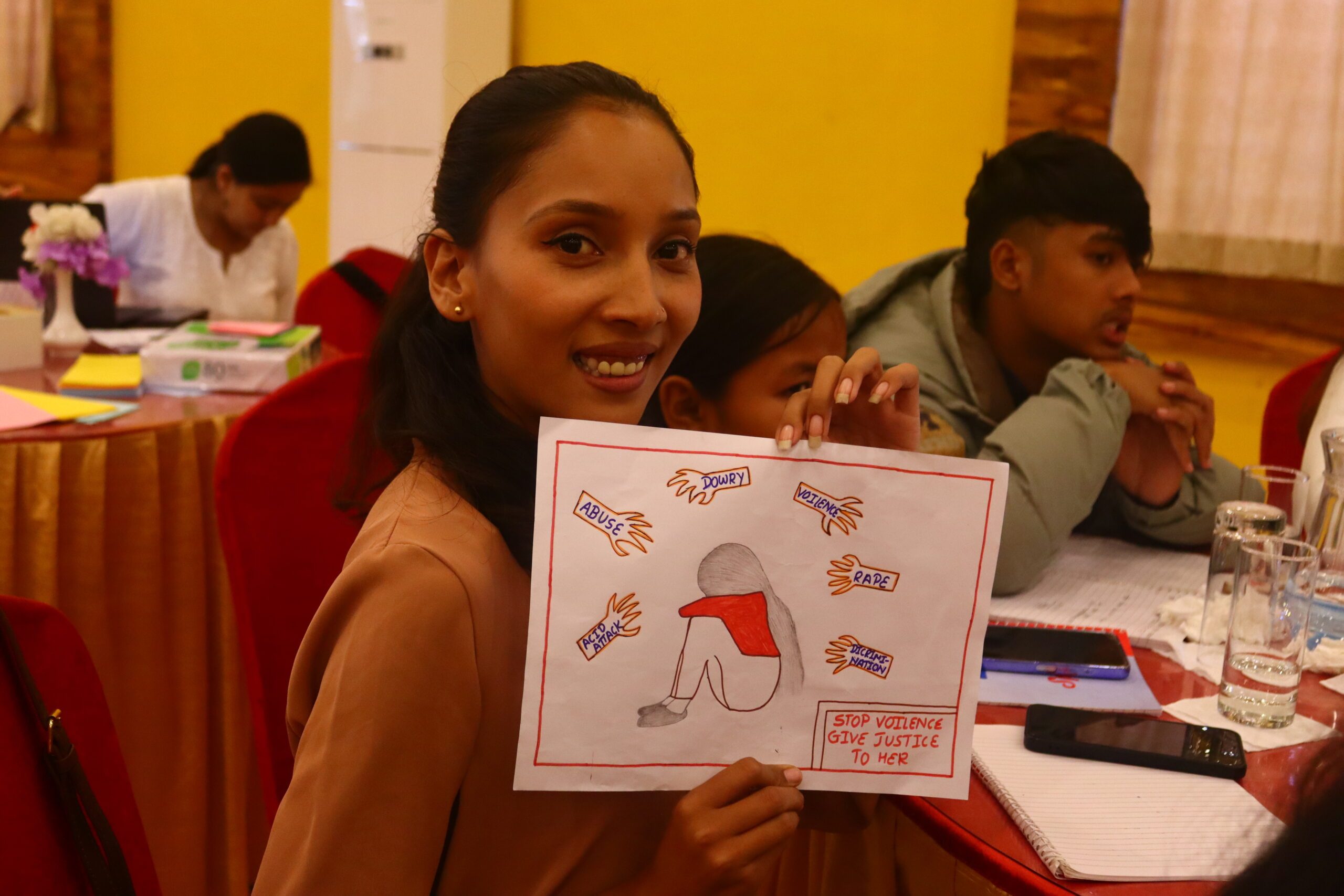 A young woman showing her art which says stop violence, give justice to her.