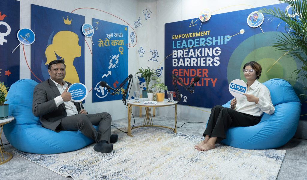 Country Director on left and Smarika on right holding placards.