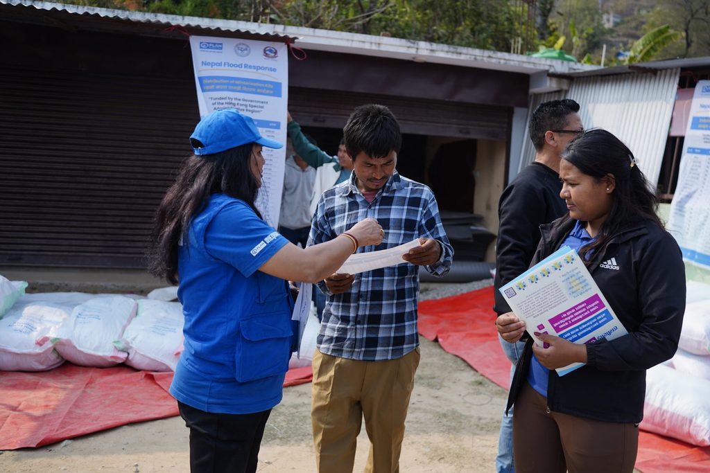 Anju distributing the flyer to community members with the information on feedback mechanism.