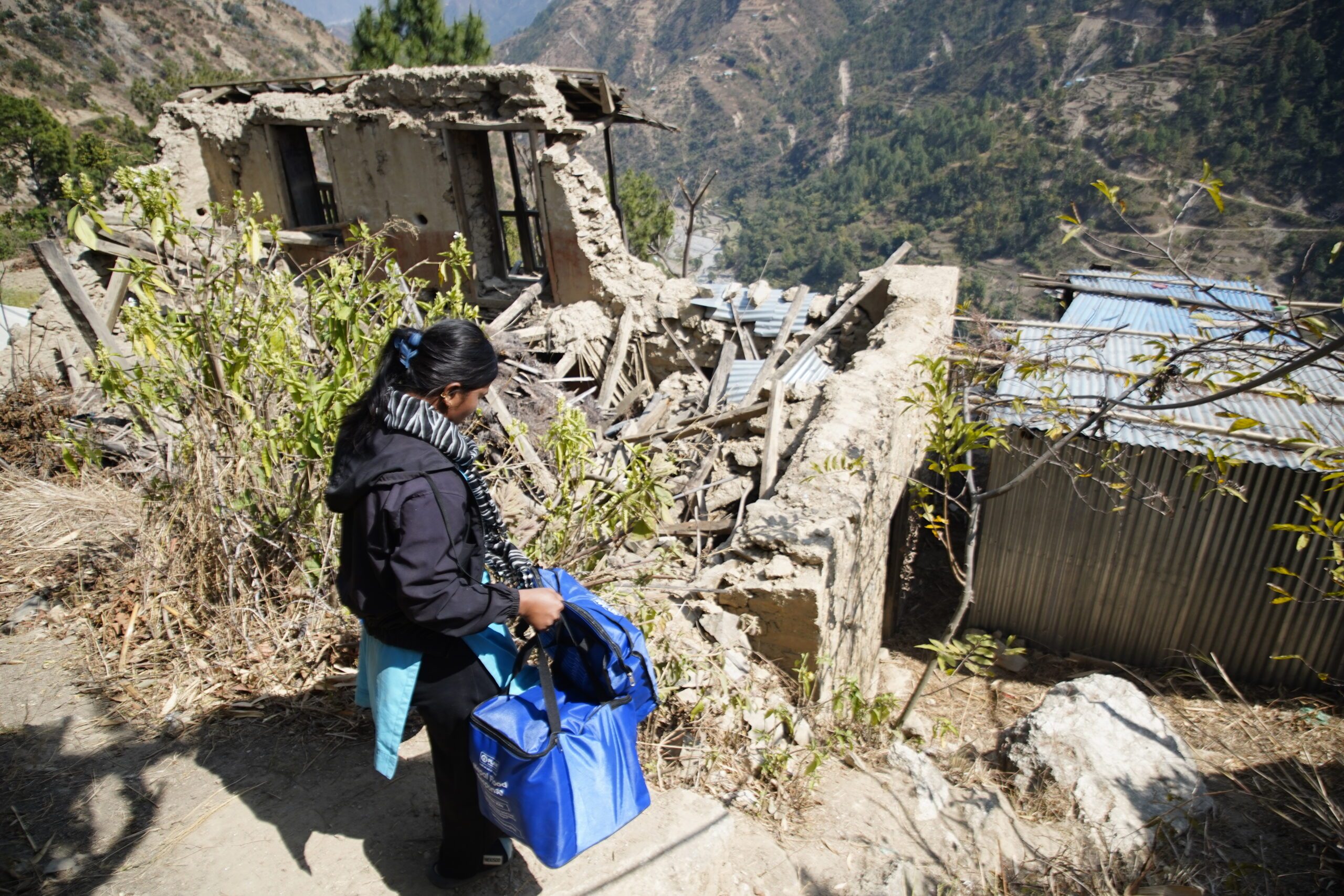 Susma walking with relief package towards her home affected by flood last year.
