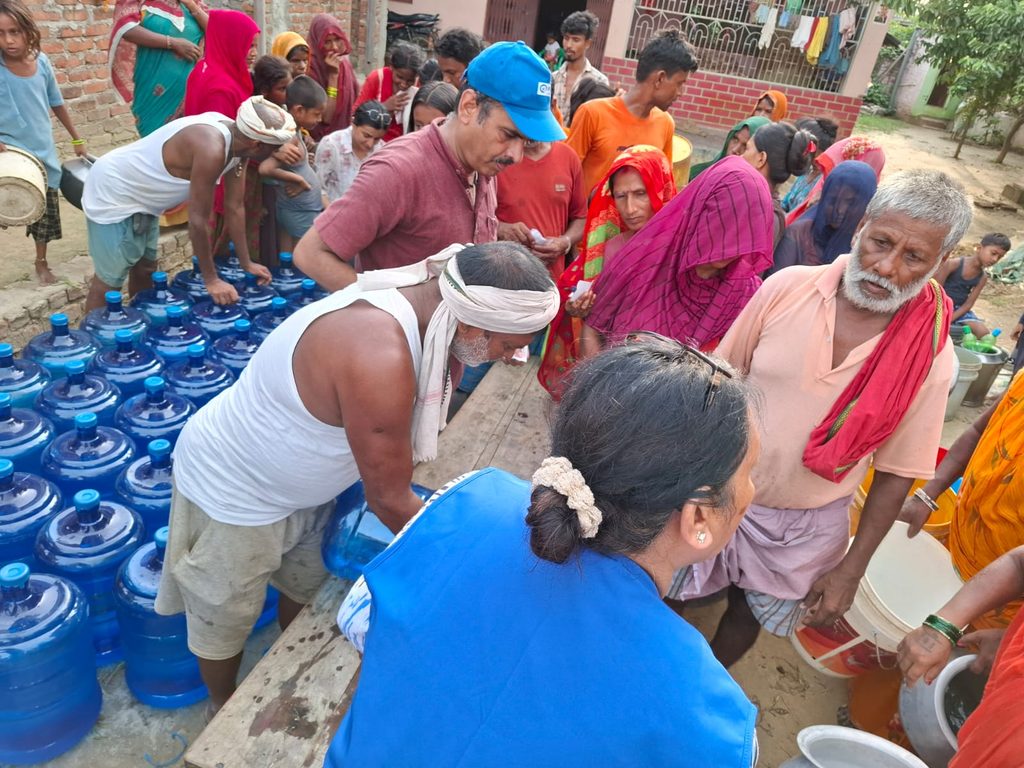 Plan staff explaining the process of clean water distribution to community people.