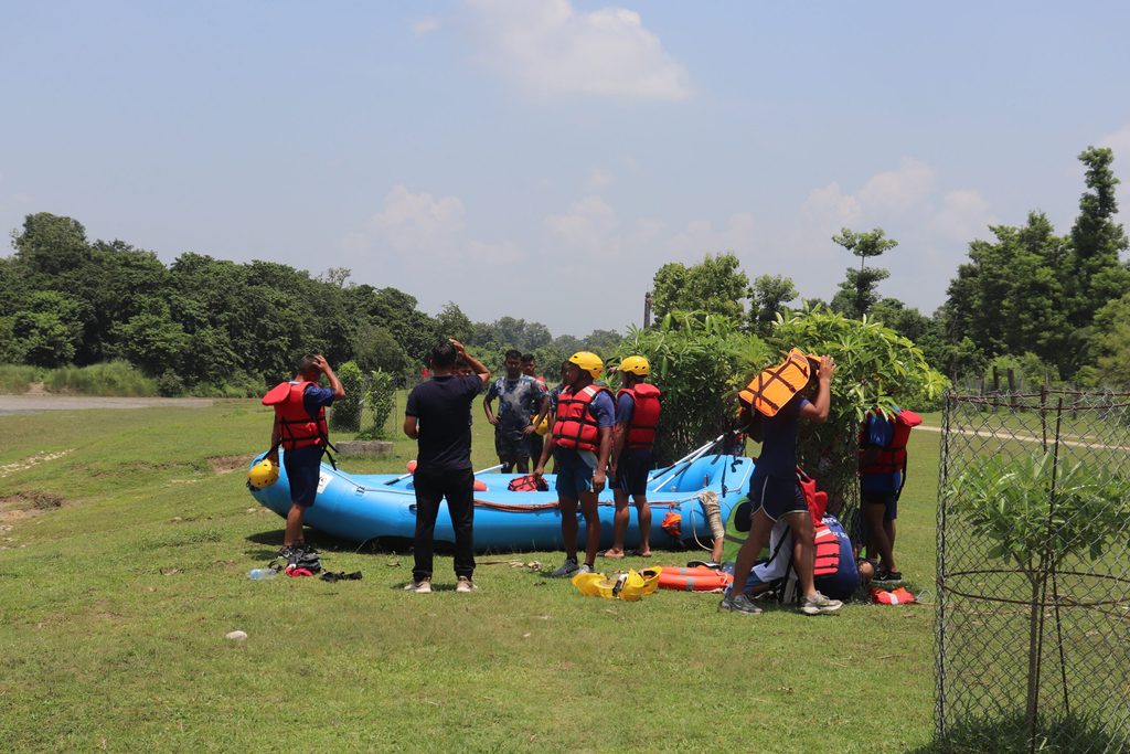 Participants practise rescue using a simple raft during a flood safety drill in Thakurbaba.