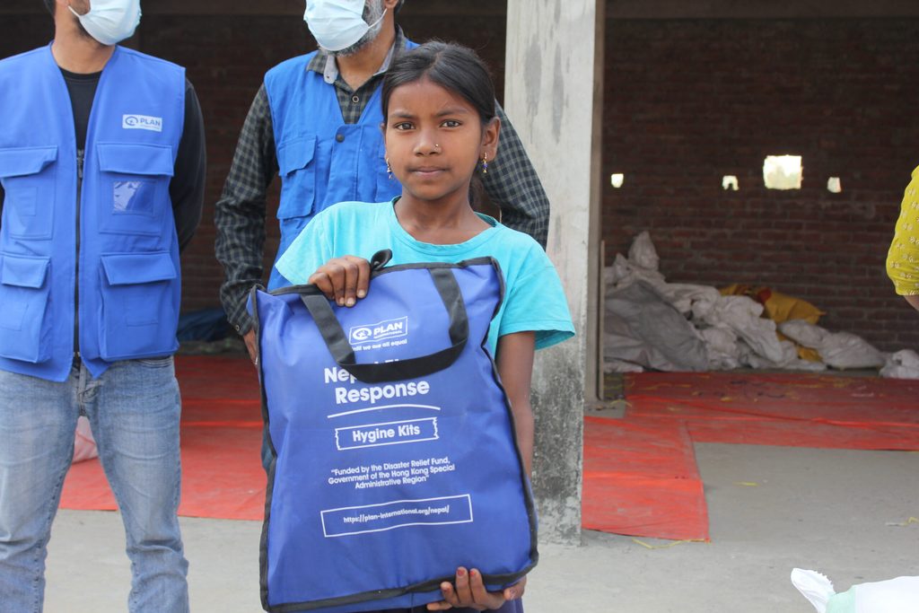 A girl holding hygiene kits received during relief distribution in Sarlahi.