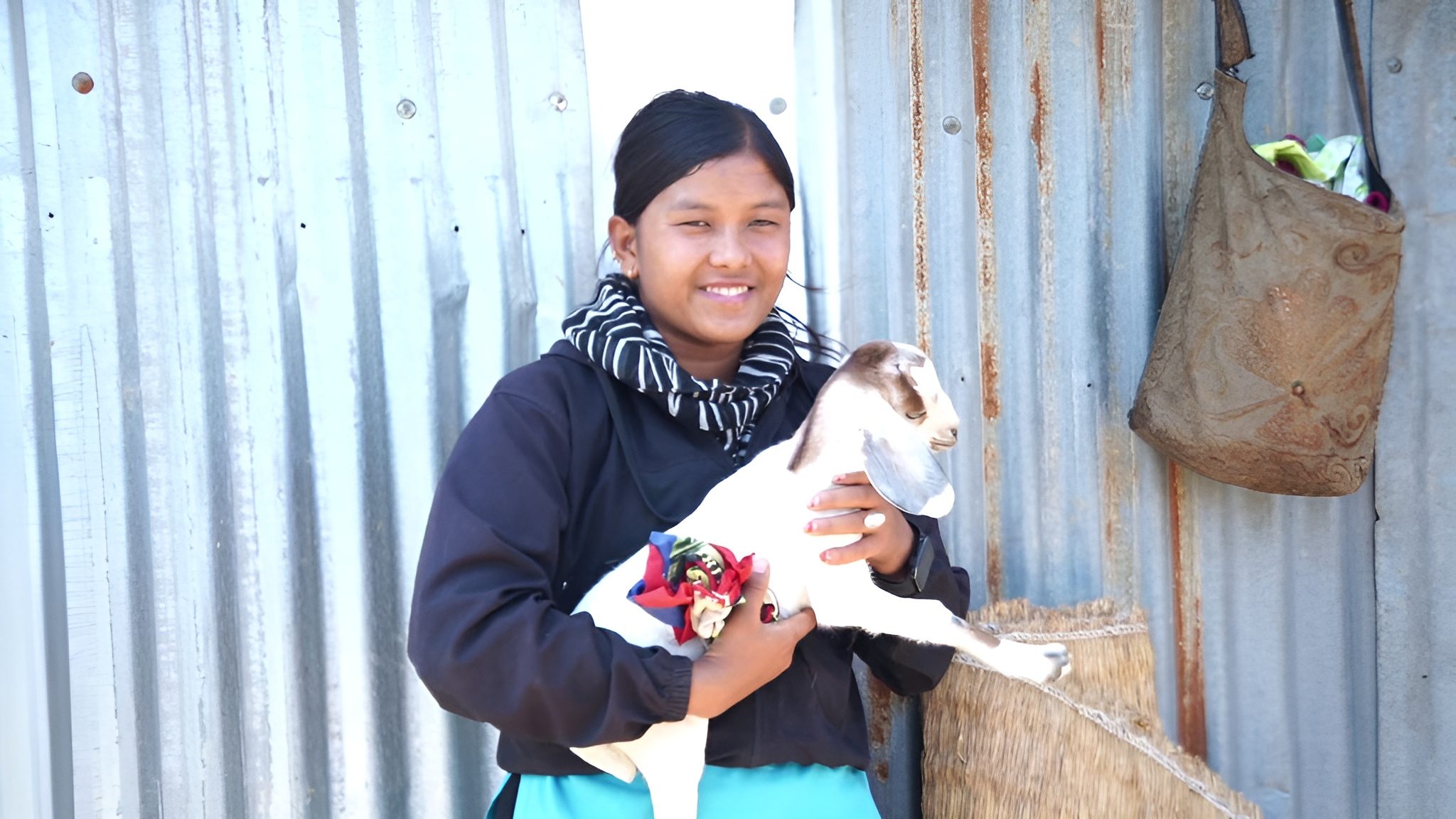 A young girl Susma holding her pet in her arms.