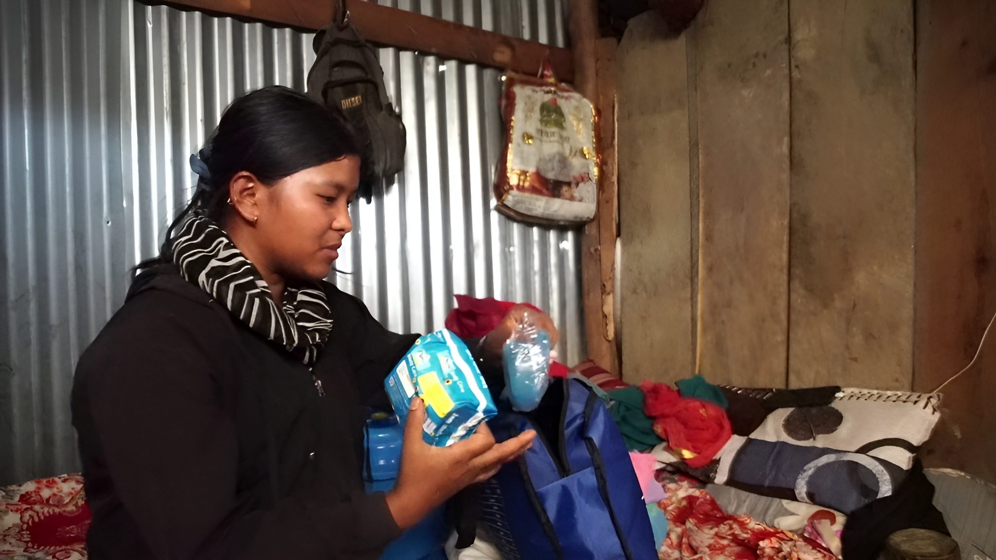 Young girl Susma holding sanitary pads in her home.
