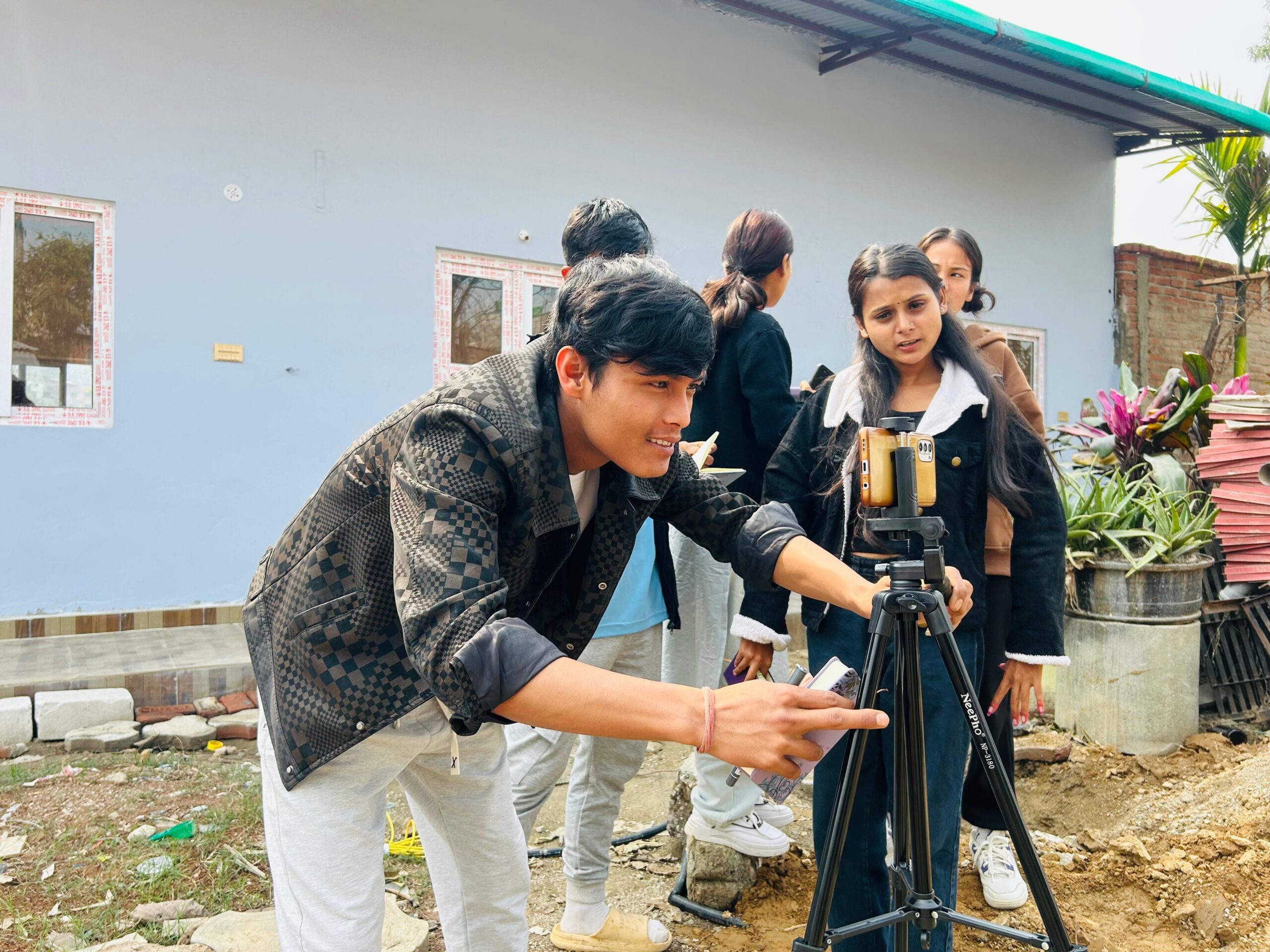 A man holding a camera stand and a girl is learning from him.