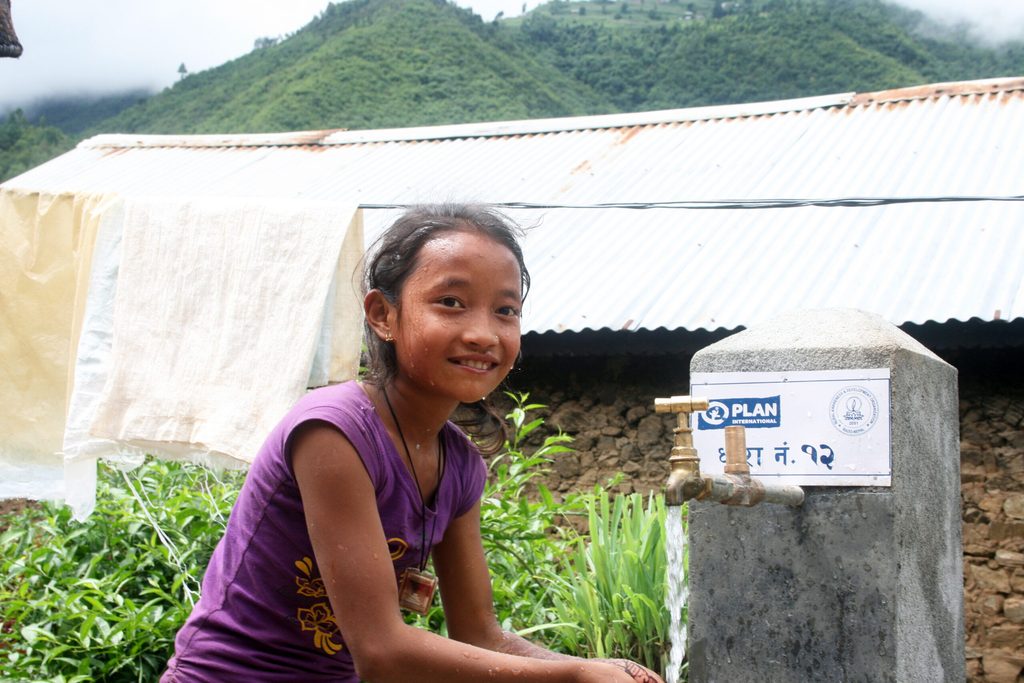 A girl washing her face.