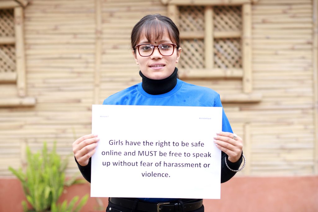 A girl holding a placard with information on online safety.