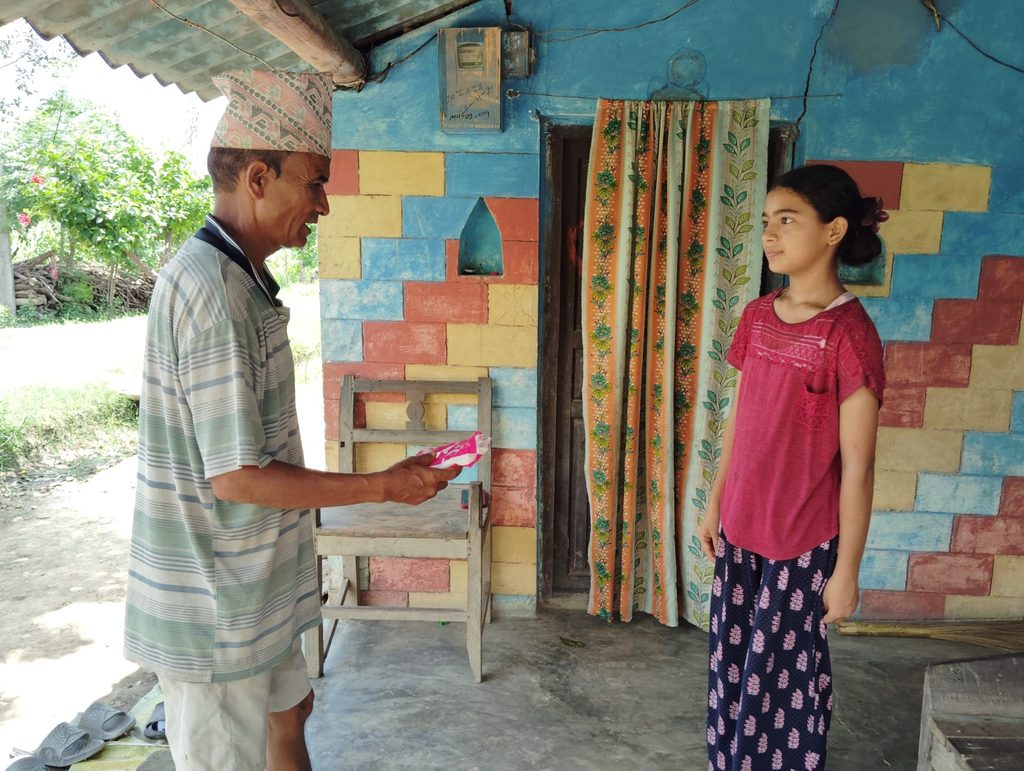 Gyan Bahadur giving sanitary pad to her daughter.