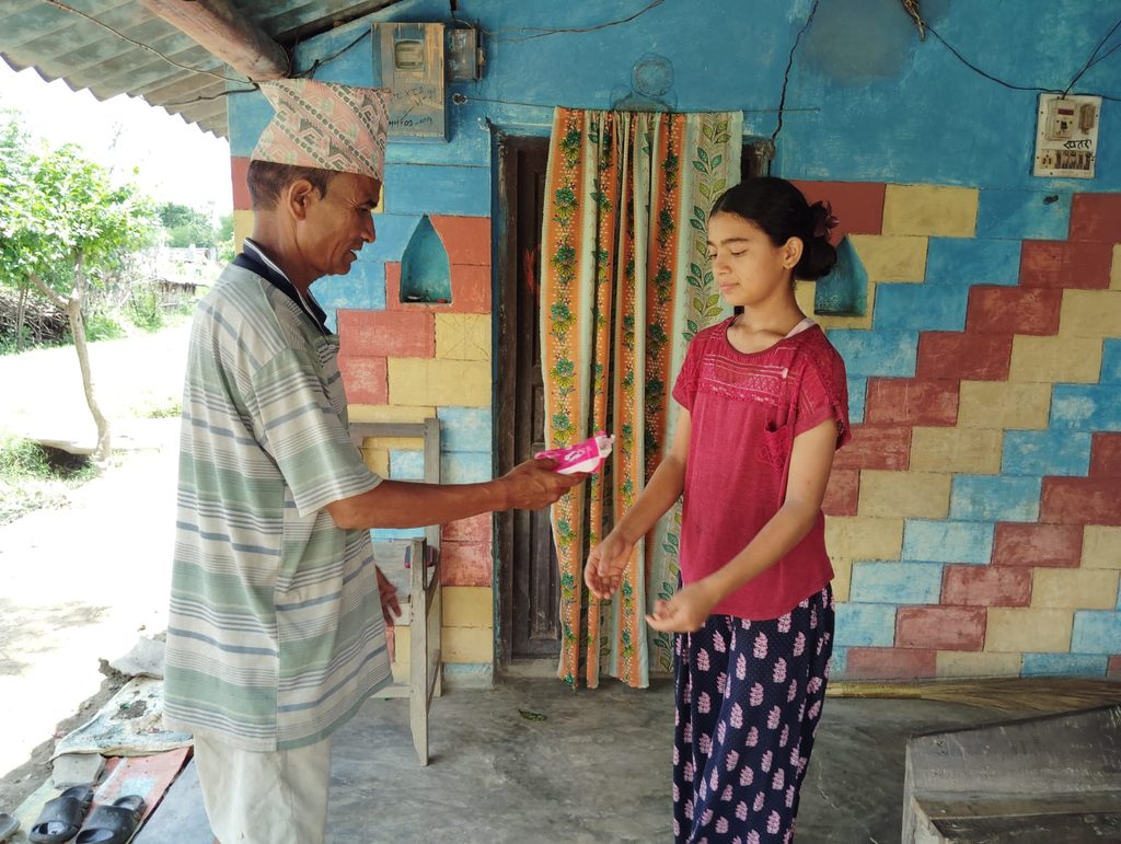 Gyan Bahadur giving sanitary pad to her daughter.