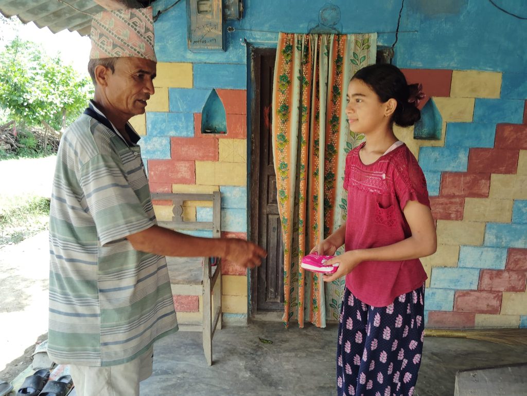Gyan Bahadur giving sanitary pad to her daughter.