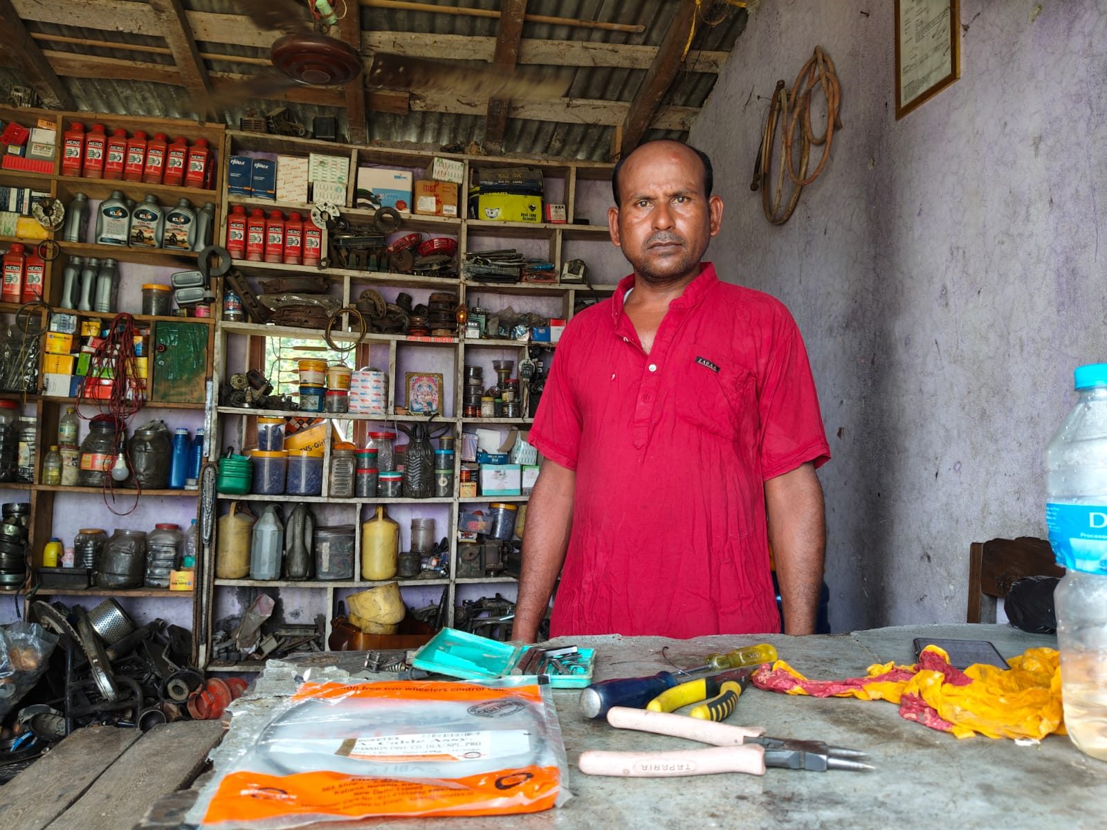Narendra stands proudly inside his garage, surrounded by tools and equipment.
