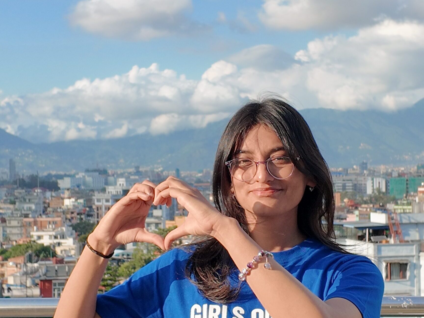 A young girl Sikha wearing Girls Out Loud tshirt and making heart shape with her hands.