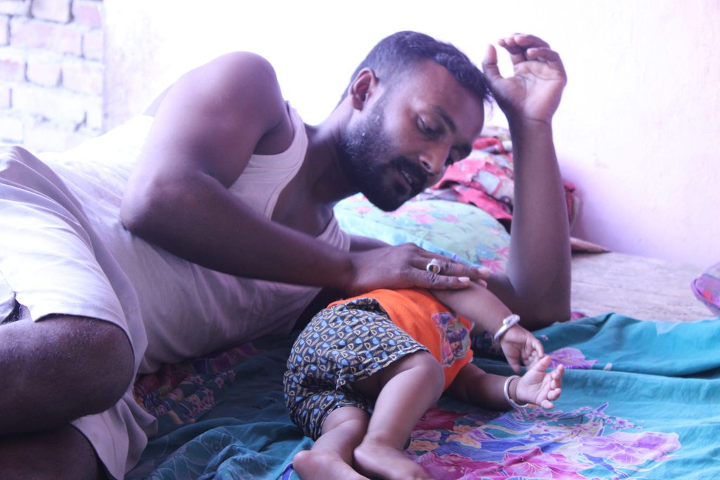 Father helping his child to sleep sound on the floor.