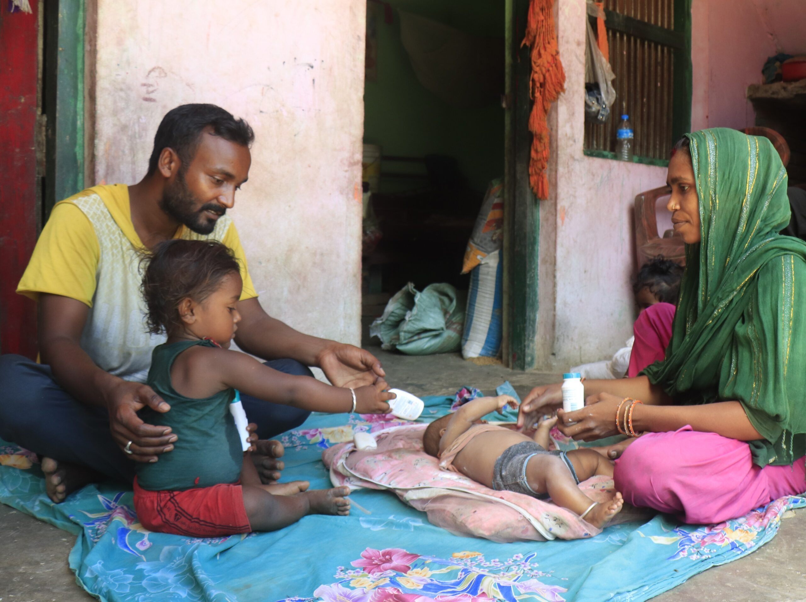 Tarani, a father (left) with his child and wife (right) sitting together and enjoying good time.