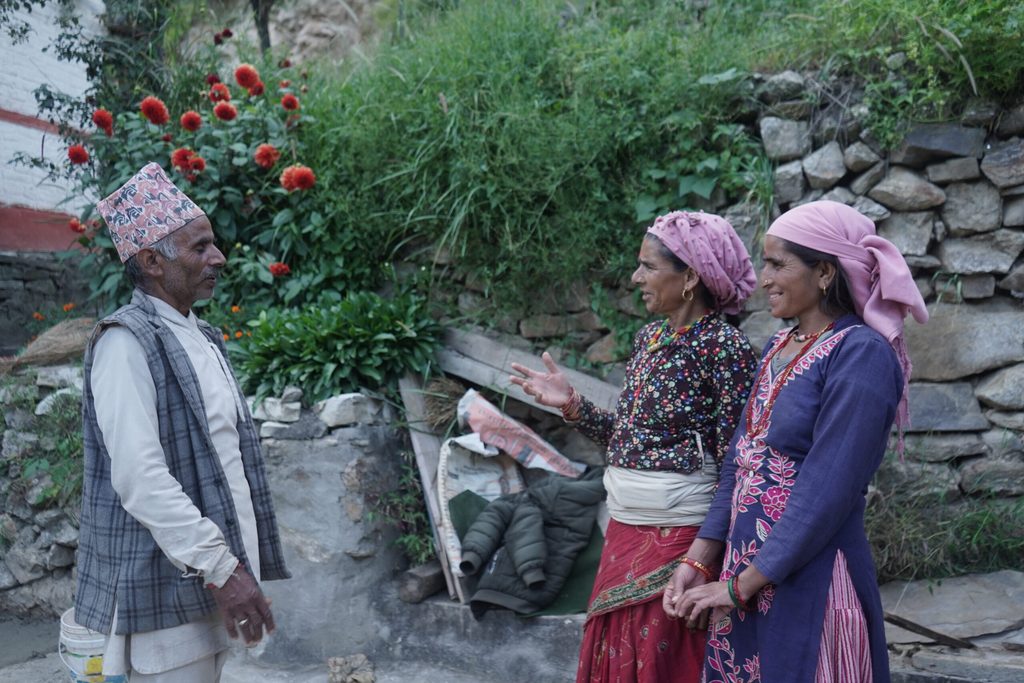 A religious leader (left) talking with two women (right)
