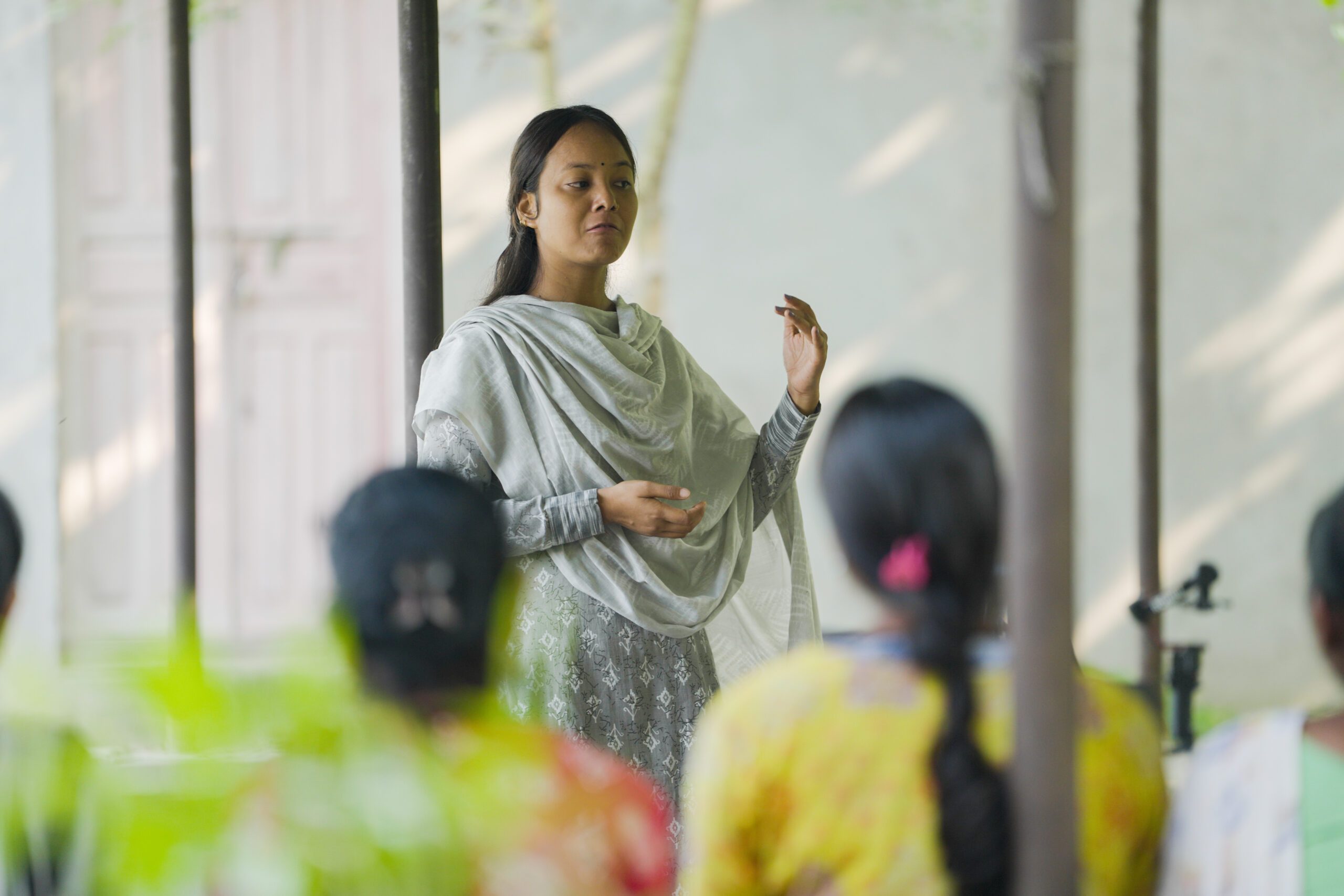 A young women Pramisha standing in front and running session to end child marriage. 