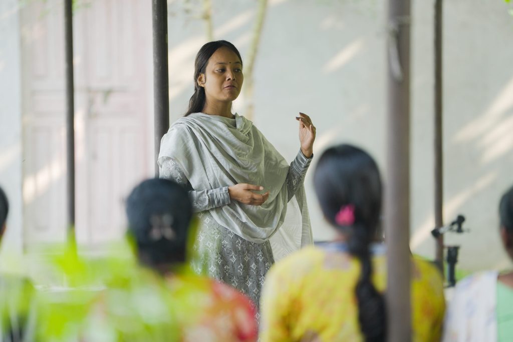 A young women Pramisha standing in front and running session to end child marriage.