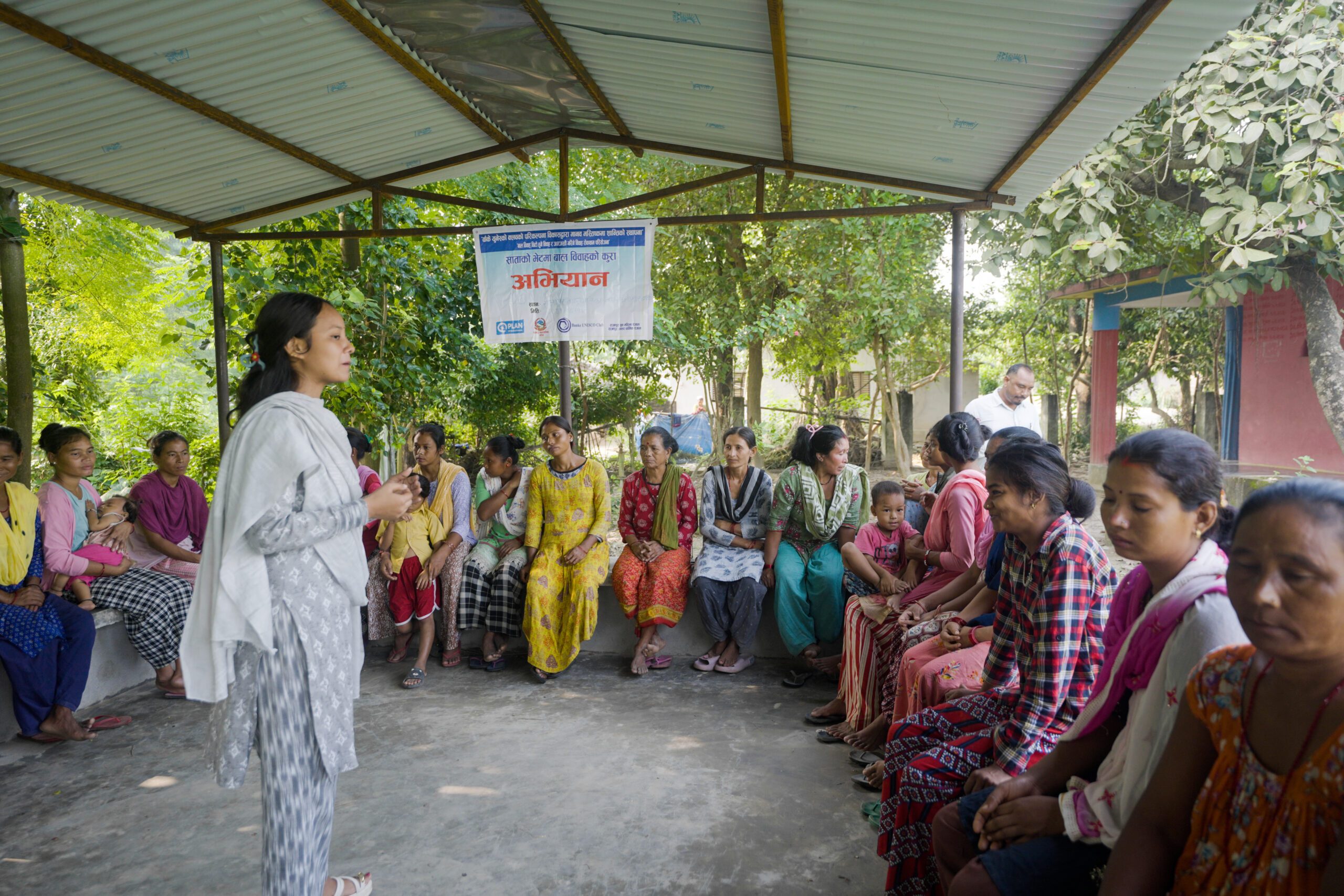 A young woman, Pramisha, standing in front of women discussing about ending child marriage.