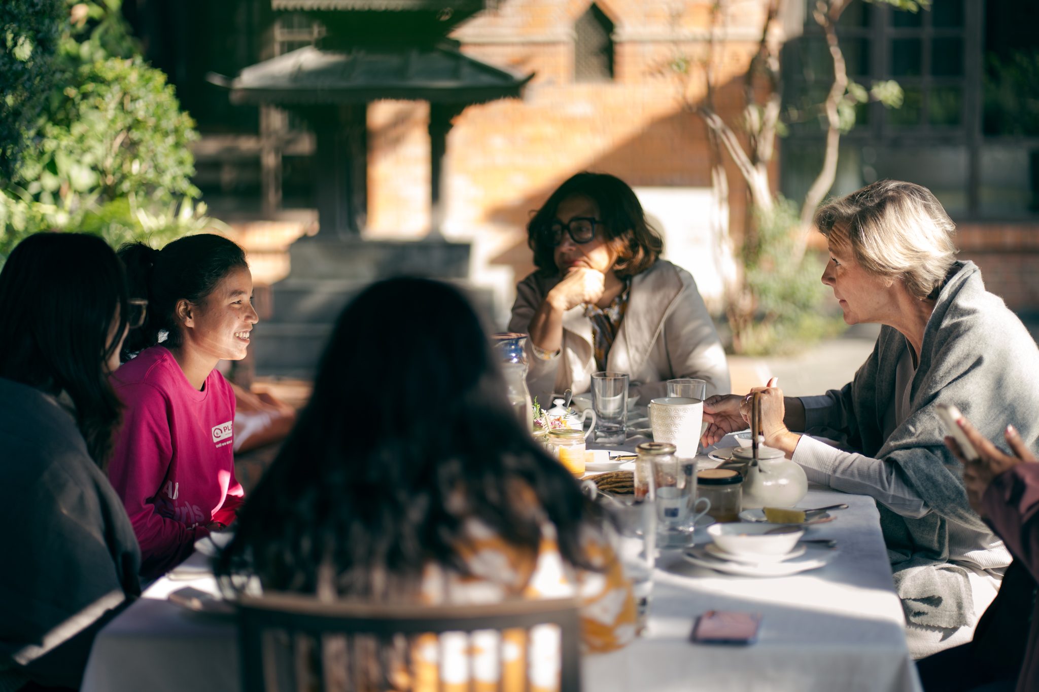 Aruna (left) sitting with H.E. Veronique (right) on breakfast table.