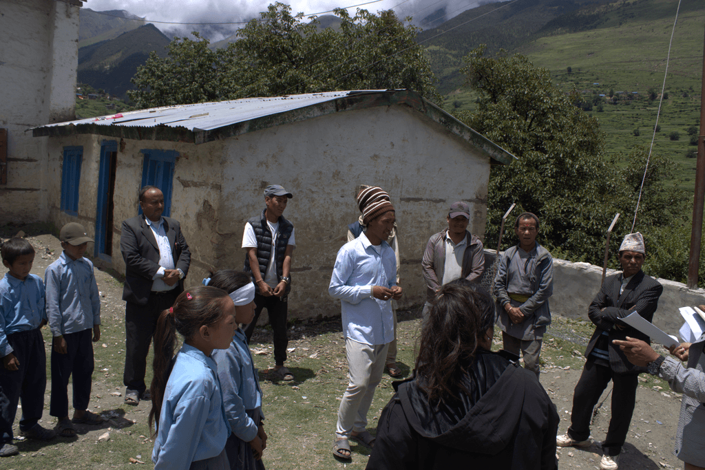 Gorkha stands in the middle of a circle of community members, facilitating a discussion on breaking harmful gender stereotypes.