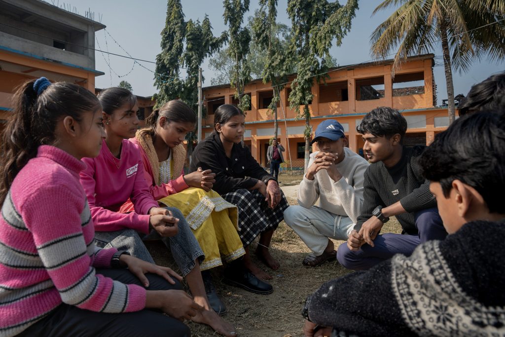 A group of young people (8) sitting in a garden.