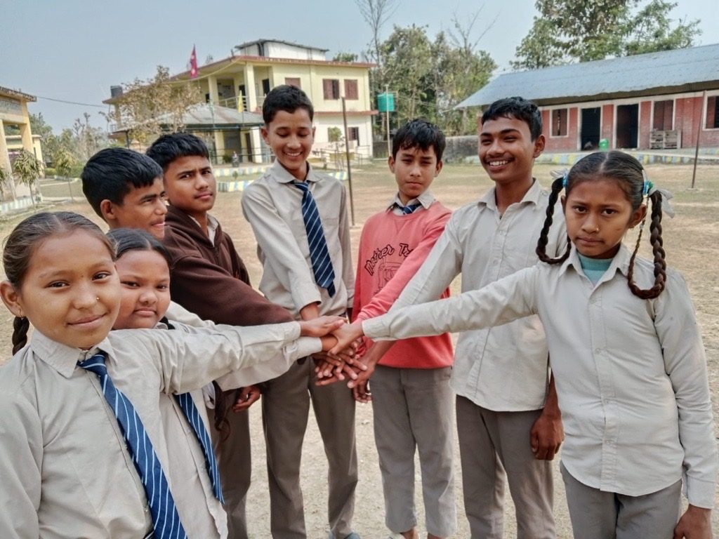 Rohit (2nd from right) with his friends in front of his school holding hands.