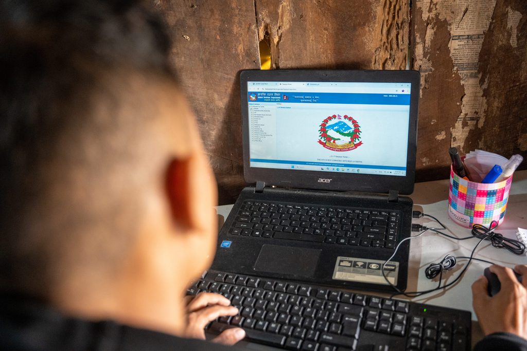 Bigyan is looking in his laptop screen displaying government logo.