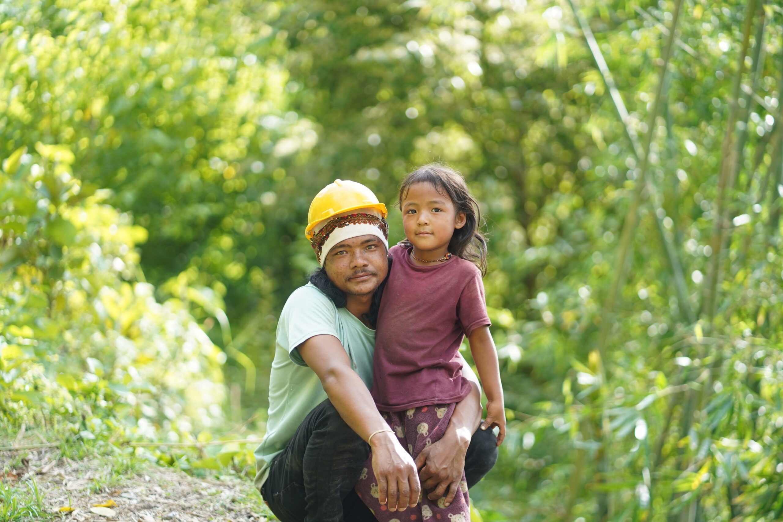 Som Lal is wearing yellow hard hat and is with her daughter,