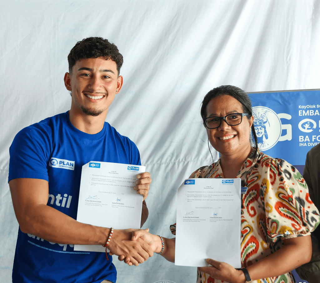 Youth Ambassador in all diversity holds up signed memorandum of understanding extension with Plan International Timor-Leste.