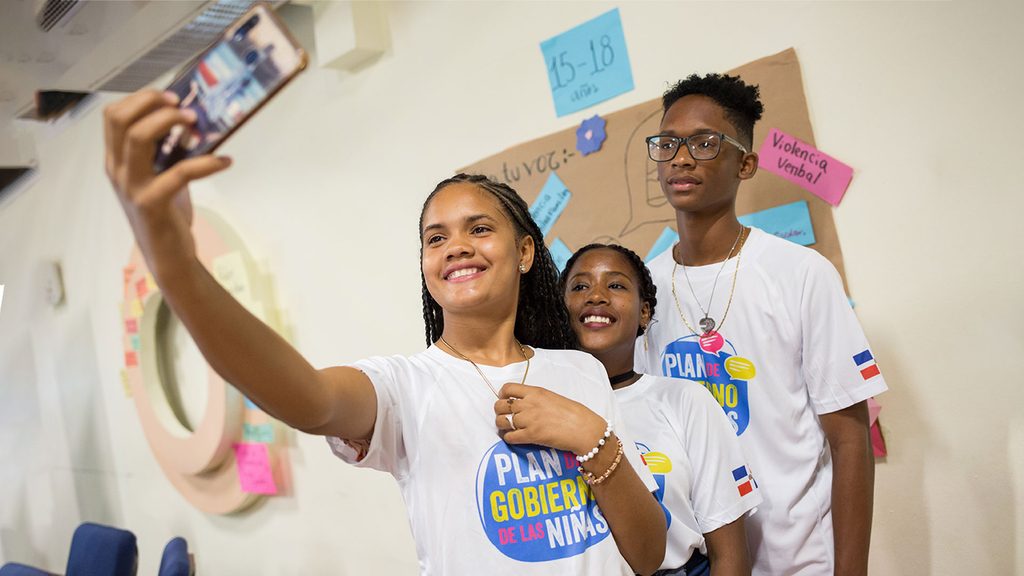 jovenes-tomando-una-selfie-con-la-camiseta-de-la-campana-organizada-por-plan-internacional-rd