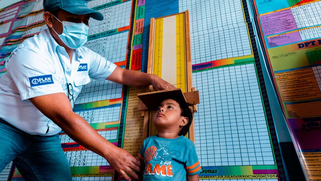 Colaborador-plan-internacional-guatemala-atiende-medicamente-a-niño