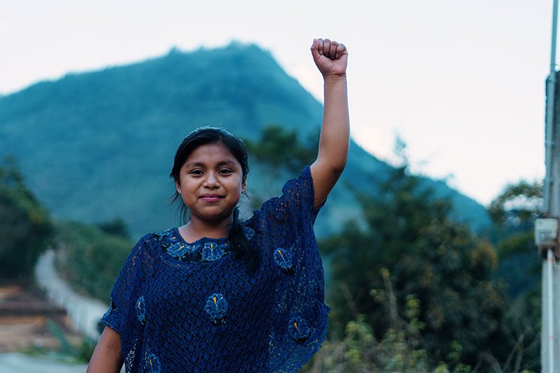Niña de Guatemala alzando el brazo empoderada por las acciones de Plan Internacional Guatemala