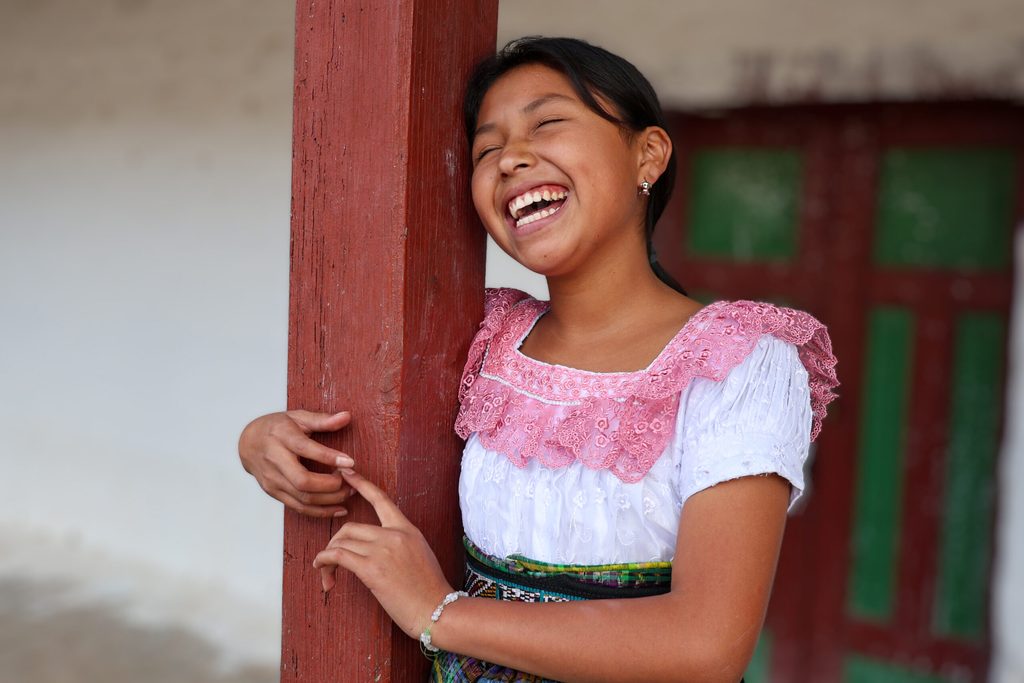 Kimberly sonriendo en su casa, en un entorno rural de Guatemala.