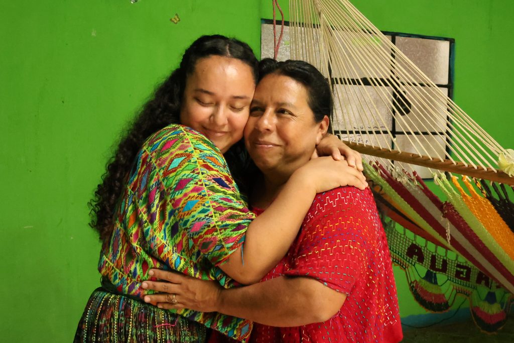 Joven lideresa abrazando a su mamá con afecto.