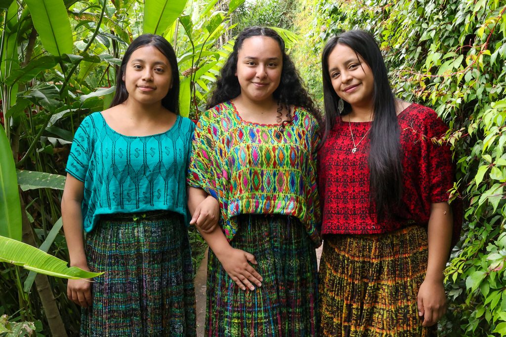 Tres jóvenes lideresas posando juntas.
